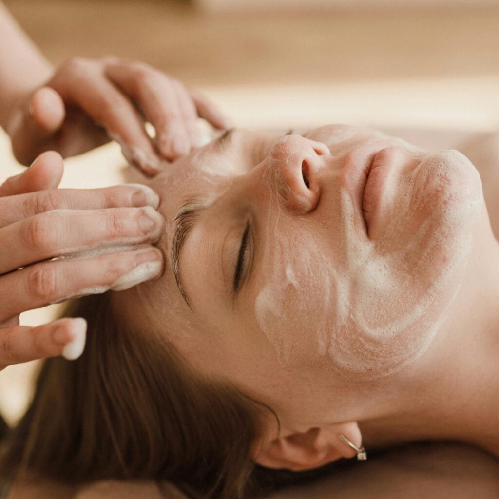 pexels-photo-6663368-6663368 A close-up of a woman receiving a soothing facial massage with a skincare mask.